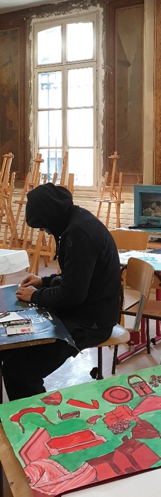 Un usager en pleine création
Nous pouvons apercevoir au premier plan une création d'un usager, et au second plan un usager assis à table et en train de faire sa création