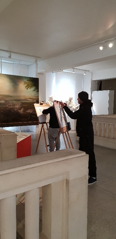 Une photographie dans une des salles du musée. Un usager est en train de réaliser un atelier